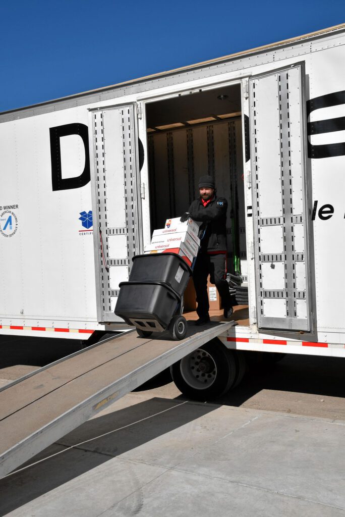 A man loading boxes onto the back of a truck.